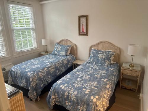 a bedroom with two beds and two windows at TROPICAL Palm Beach WIFI 2BEDROOM 2BATHROOM OutdoorPOOL Beach Garden in Palm Beach