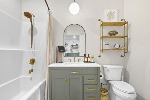 a bathroom with a sink and a toilet and a mirror at Baby Birch Banks Guest House on Lake Pend Oreille in Sagle