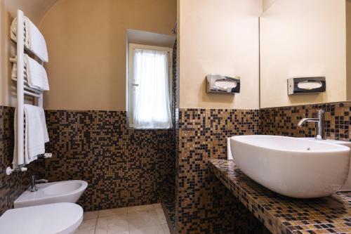 a bathroom with a white sink and a toilet at Residenza d'Epoca Relais I Miracoli in Pisa