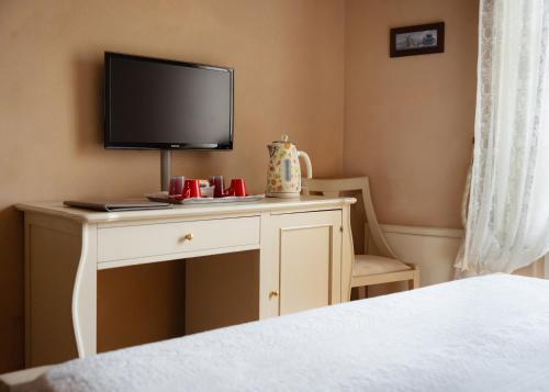 a bedroom with a desk with a television on it at Residenza d'Epoca Relais I Miracoli in Pisa