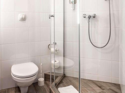 a bathroom with a toilet and a shower at Hotel Ibis Krakow Centrum in Kraków