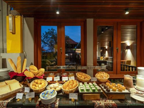 a buffet with different types of food on a table at Mercure Kuta Bali in Kuta