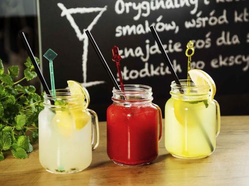 three drinks in mason jars on a table with a chalkboard at Hotel Ibis Krakow Centrum in Kraków