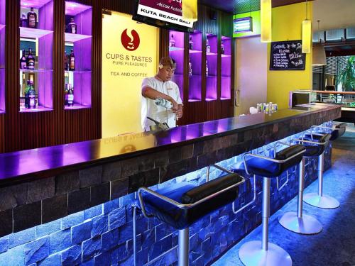 a man standing at a bar in a restaurant at Mercure Kuta Bali in Kuta