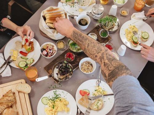 a table full of plates of food with two people with tattoos at Hotel Ibis Krakow Centrum in Kraków