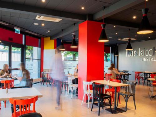 a restaurant with tables and chairs and people sitting at tables at Ibis Warszawa Stare Miasto in Warsaw