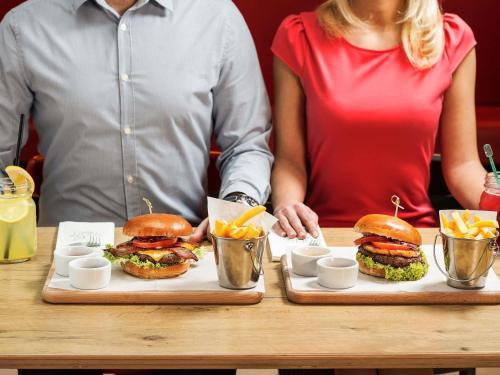 two people sitting at a table with sandwiches and chips at Ibis Warszawa Stare Miasto in Warsaw