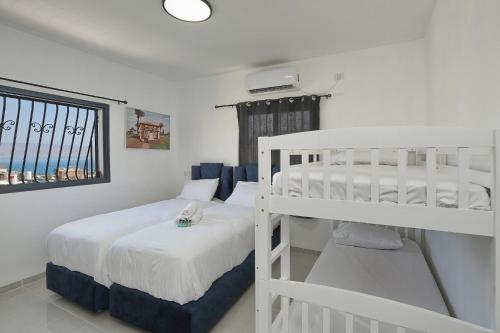 a bedroom with two bunk beds and a window at Levication Multiple Apartments - Family Stays Tiberias in Tiberias