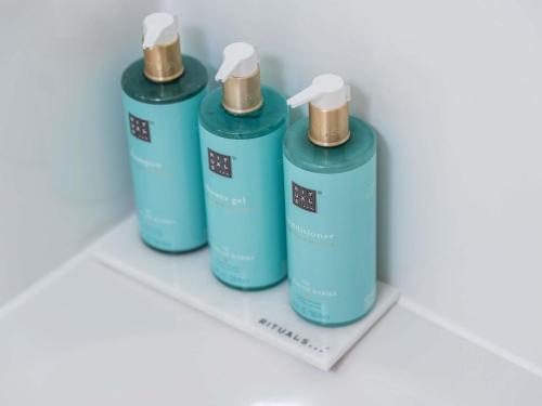 a group of three blue bottles on a shelf at Novotel Suites Wien City Donau in Vienna