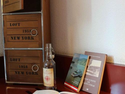 a bottle of wine sitting on a table next to a book at Novotel Suites Wien City Donau in Vienna