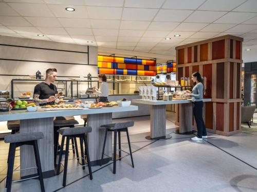 a group of people preparing food in a kitchen at Novotel Suites Wien City Donau in Vienna