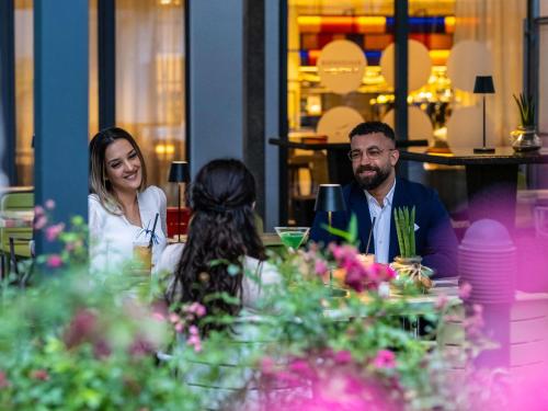 a man and woman sitting at a table in a restaurant at Novotel Suites Wien City Donau in Vienna