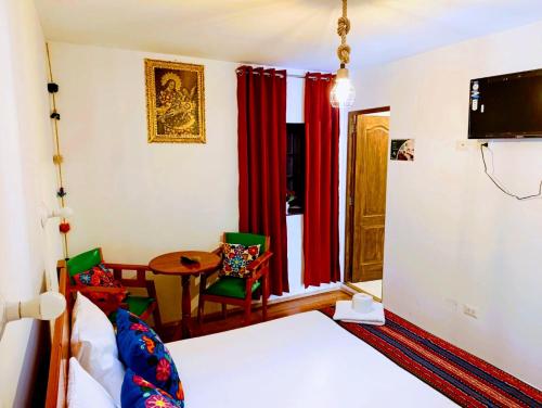 クスコにあるEcoterra Pampa del Castilloのベッドとテーブルと椅子のある寝室