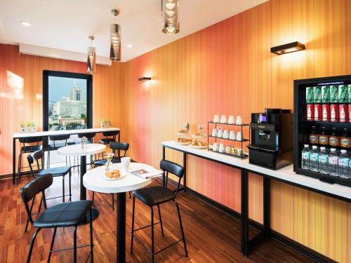 a restaurant with tables and chairs and a bar at Ibis Styles Ambassador Seoul Gangnam in Seoul