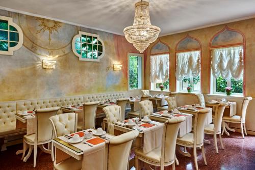 un restaurante con mesas y sillas y una lámpara de araña en Hotel Gardena en Venecia