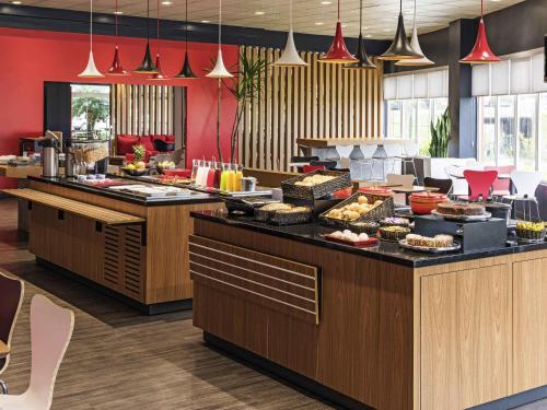 a buffet line with food on display in a restaurant at ibis Curitiba Aeroporto in São José dos Pinhais