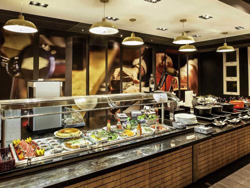 a buffet line with food on display in a restaurant at ibis Macae in Macaé