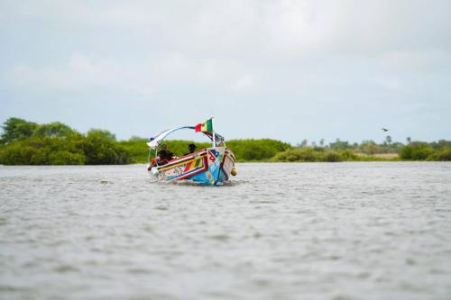 a small boat in the water on a lake at Maison flottante SWEET MALBALY - chambre double - vue imprenable sur mer- iles du saloum in Fatick