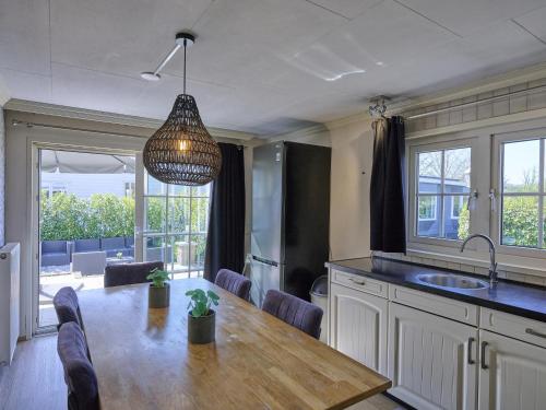 a kitchen with a table and a pendant light at t Kaatsheuveltje 2 in Sprang-Capelle