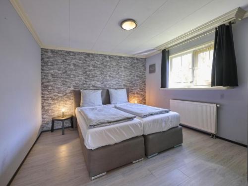 a bedroom with a bed and a brick wall at t Kaatsheuveltje 2 in Sprang-Capelle
