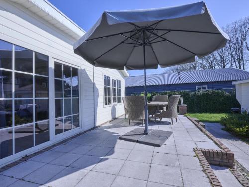 a patio with a table and an umbrella at t Kaatsheuveltje 2 in Sprang-Capelle