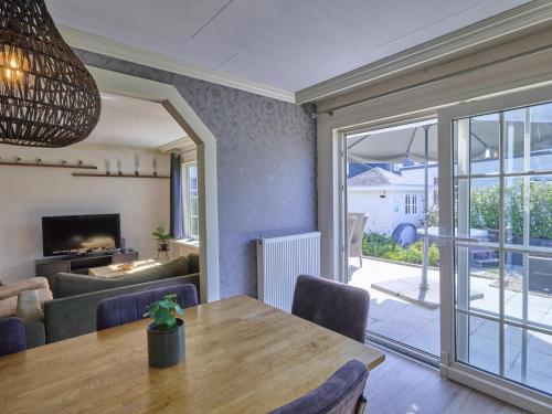 a dining room with a table and a living room at t Kaatsheuveltje 2 in Sprang-Capelle