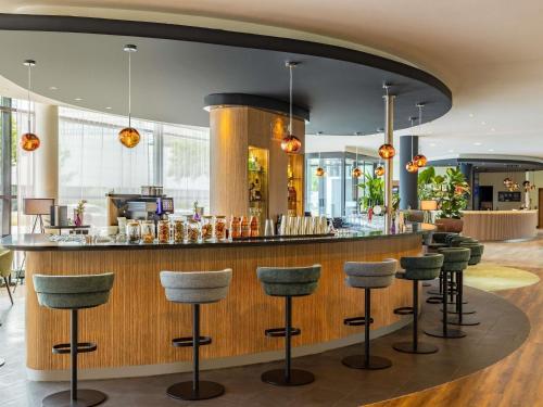 a bar in a restaurant with stools at Novotel Hamburg City Alster in Hamburg
