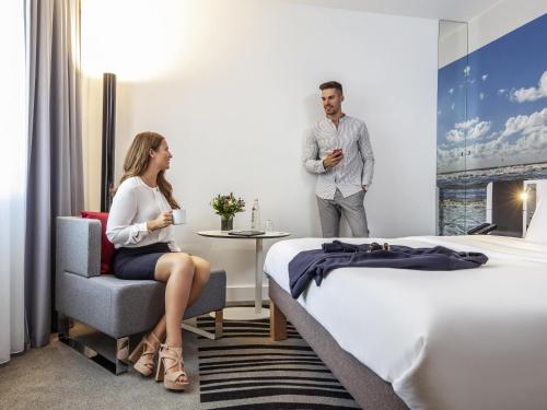 a man and a woman in a hotel room at Novotel Hamburg City Alster in Hamburg