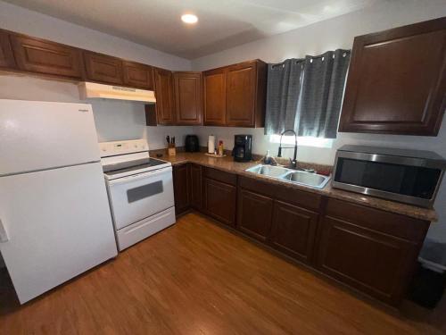 a kitchen with a white refrigerator and a sink at Flowers Apt 5 Min Walk to Downtown - Free Parking in Las Vegas