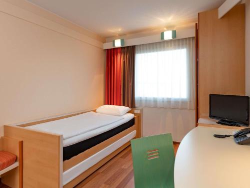 a small room with a bed and a television at ibis Berlin City Potsdamer Platz in Berlin