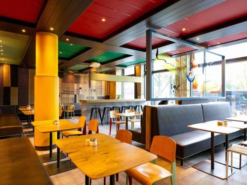 a dining room with tables and chairs andwindows at ibis Berlin City Potsdamer Platz in Berlin
