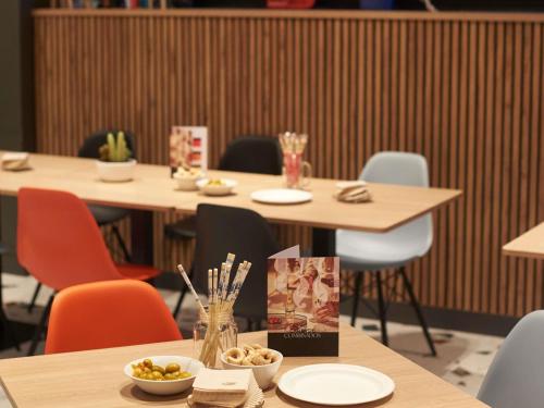 a group of tables with chairs and bowls of food at Ibis Madrid Aeropuerto Barajas in Madrid