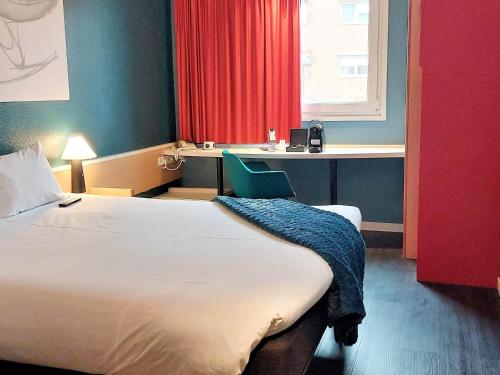 a hotel room with a bed and a desk at Ibis Madrid Fuenlabrada in Fuenlabrada