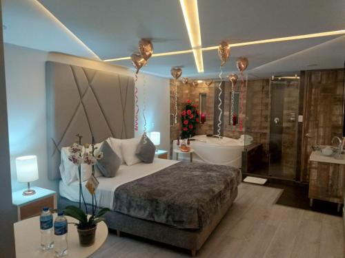 een slaapkamer met een bed, een bad en een wastafel bij Hotel Agora Boutique in Bogota