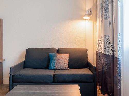 a blue couch with a pillow in a living room at Novotel Paris 17 in Paris