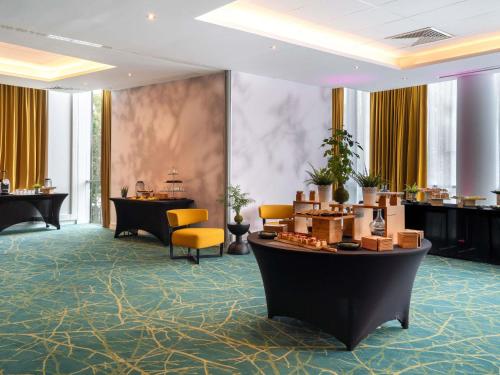 a lobby with a waiting area with chairs and tables at Novotel Paris 17 in Paris