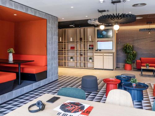 a restaurant with a table and chairs and a tv at Ibis Barcelona Aeropuerto Viladecans in Viladecáns