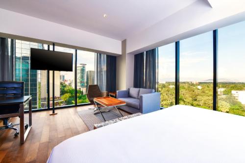 a hotel room with a bed and a desk at Krystal Grand Suites Insurgentes in Mexico City