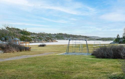 a swing set in a field next to the water at 2 Bedroom Beautiful Home In Gressvik in Slevik