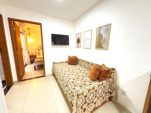 un salon avec un canapé et une télévision dans l'établissement Flat Centro de Buzios, à Búzios