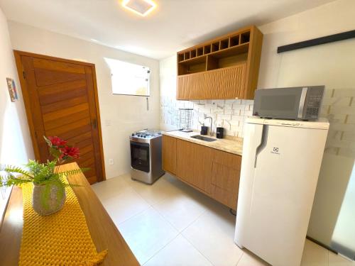 une cuisine avec un réfrigérateur et une table à l'intérieur dans l'établissement Flat Centro de Buzios, à Búzios