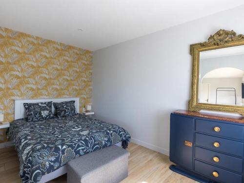 a bedroom with a bed with a blue dresser and a mirror at Gîte de Charme : Calme, Nature, Proche du Mans, Terrasse, Jardin, Parking Privé - FR-1-410-397 in Montbizot