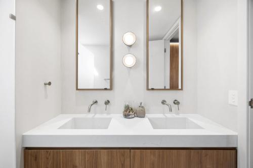 un baño con dos lavabos y dos espejos en The Watermark, en Narrawallee