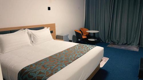 a hotel room with a bed and a chair at Vienna Motel in Paihia