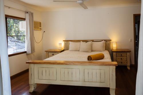 a bedroom with a large bed with a wooden headboard at Wybalena ocean views tropical big home garden pool in Port Douglas
