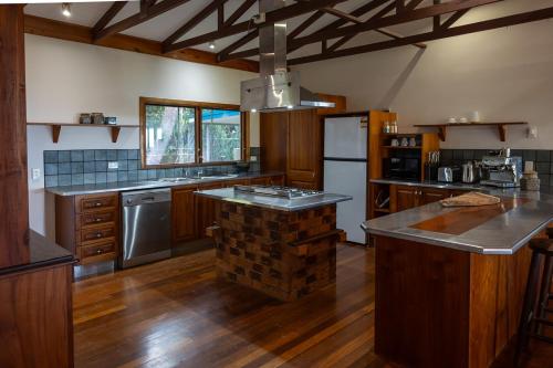 a large kitchen with a brick island in the middle at Wybalena ocean views tropical big home garden pool in Port Douglas