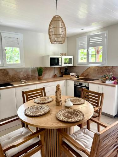 una cocina con una mesa de madera con sillas y un asterisco en Hibis Bay, en Le Morne Rouge