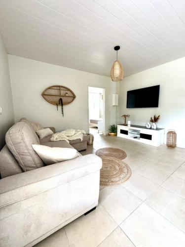 Una sala de estar con un sofá y un televisor de pantalla plana. en Hibis Bay, en Le Morne Rouge