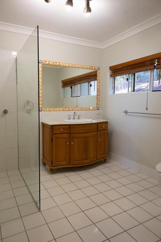 a bathroom with a sink and a mirror at Wybalena ocean views tropical big home garden pool in Port Douglas