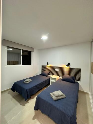a bedroom with two beds and a window at Apartamentos Anau k & L- Playa del inglés - Yumbo in Playa del Ingles